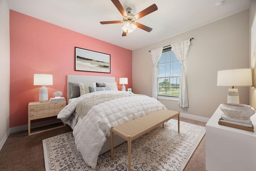This inviting secondary bedroom showcases a warm accent wall, plush carpeting, and a large window that fills the space with natural light. The neutral tones create a comfortable and versatile retreat, perfect for family, guests, or a personalized private space.