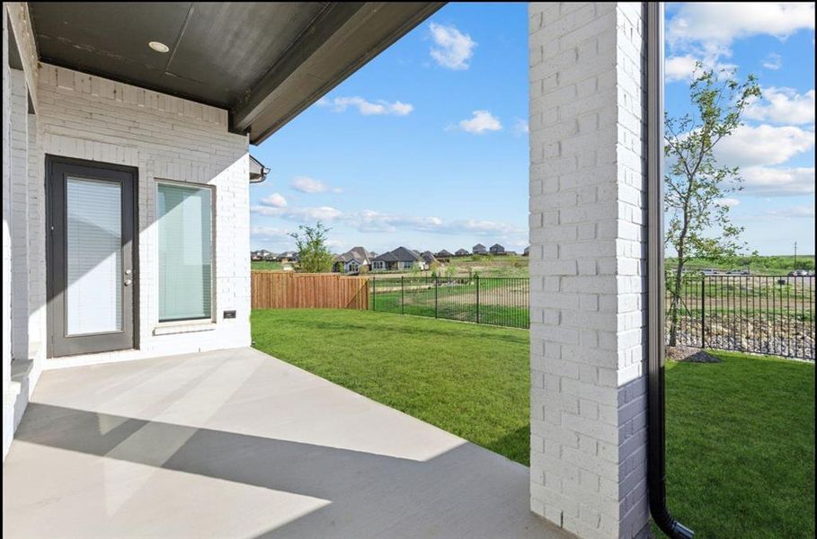 Fenced backyard featuring a patio area and a residential view