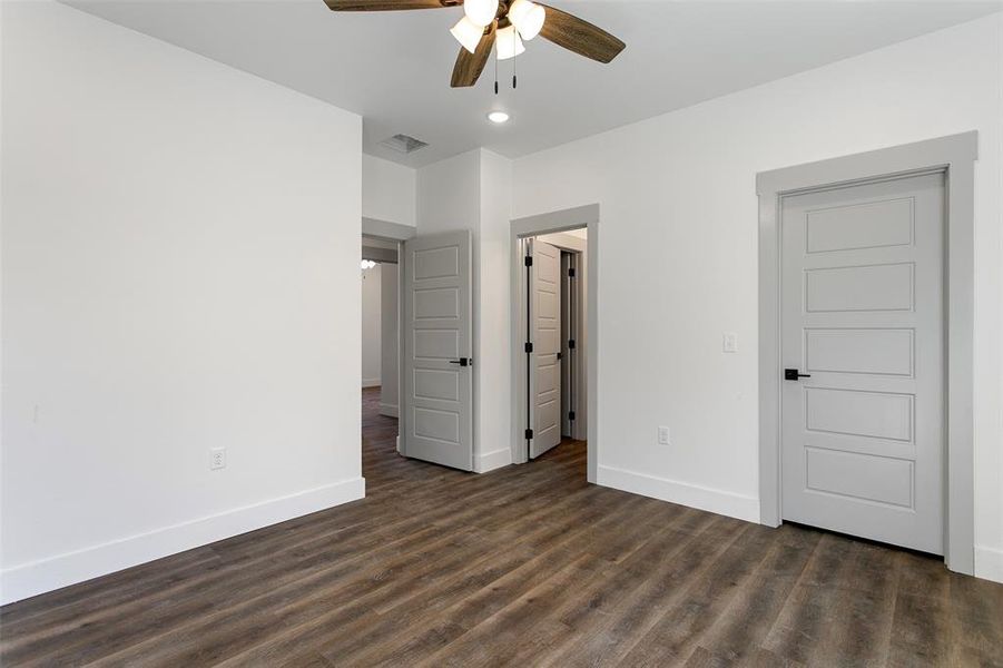 Unfurnished bedroom with dark hardwood / wood-style floors and ceiling fan