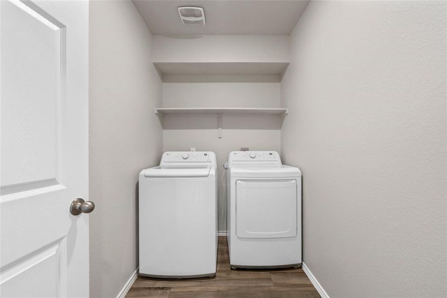 Washroom with washing machine and clothes dryer and wood finished floors Washroom with washing machine and clothes dryer and wood finished floors