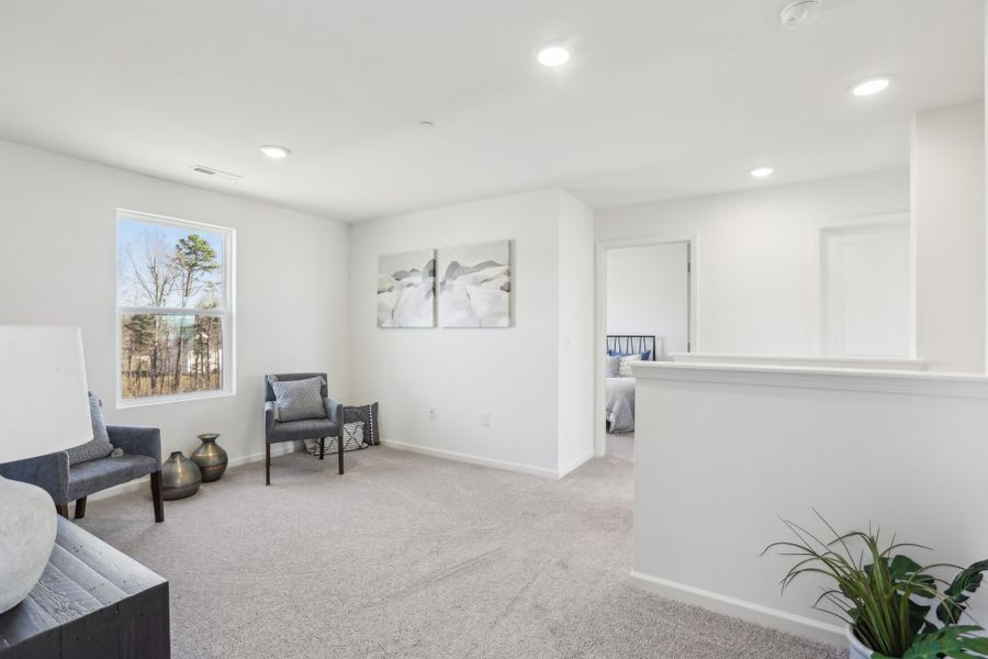 A room with a couch and chairs.