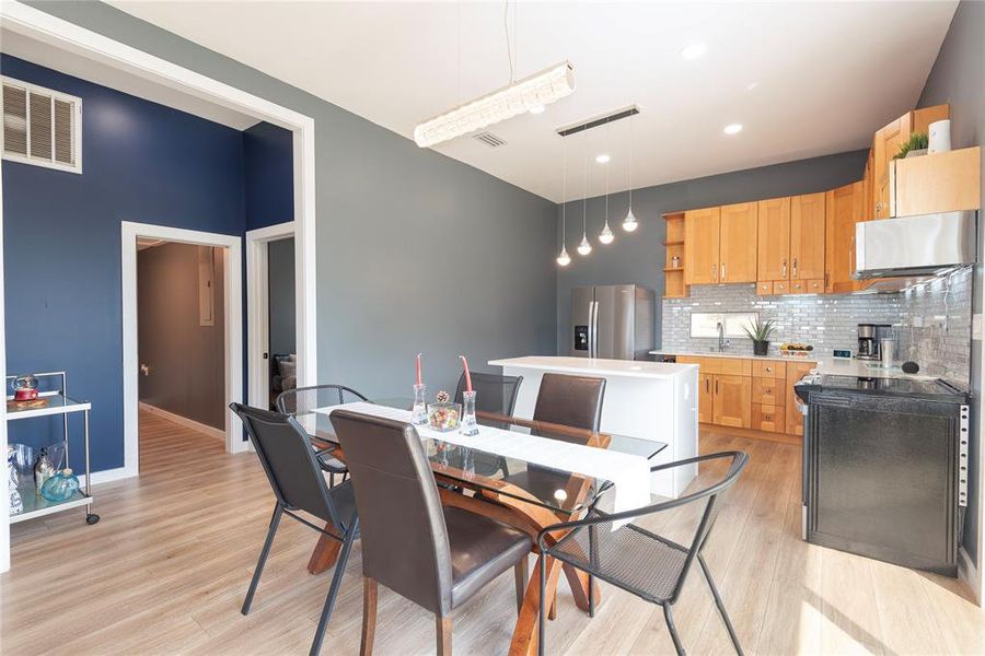 Dining space with light wood-style flooring and recessed lighting Dining space with light wood-style flooring and recessed lighting