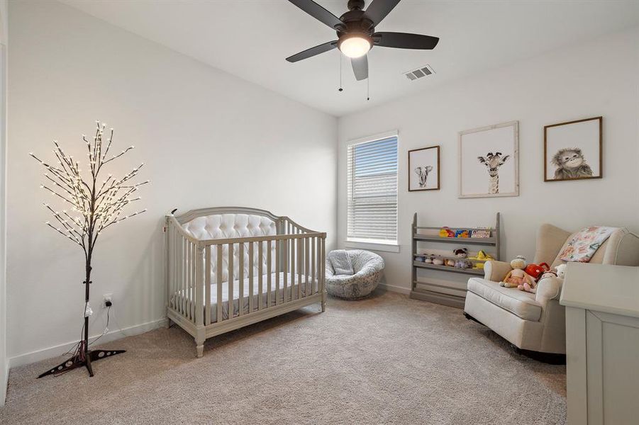 A well-lit bedroom features a ceiling fan, plush carpeting, and ample natural light from a window with blinds. A well-lit bedroom features a ceiling fan, plush carpeting, and ample natural light from a window with blinds.