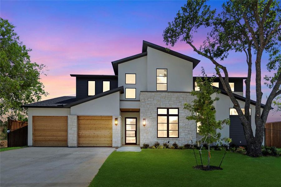 Modern home featuring a garage and a yard