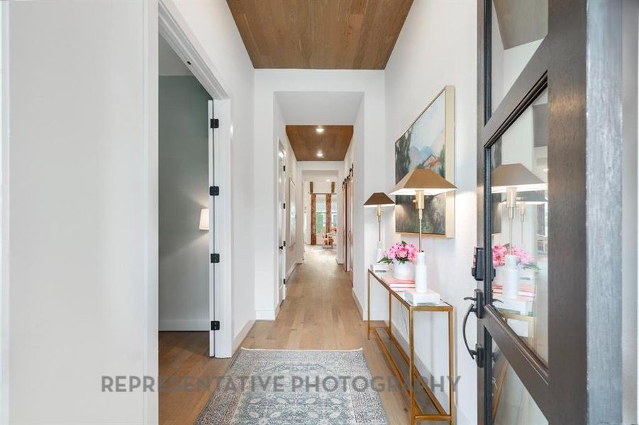 Hallway featuring light wood-style flooring and wooden ceiling