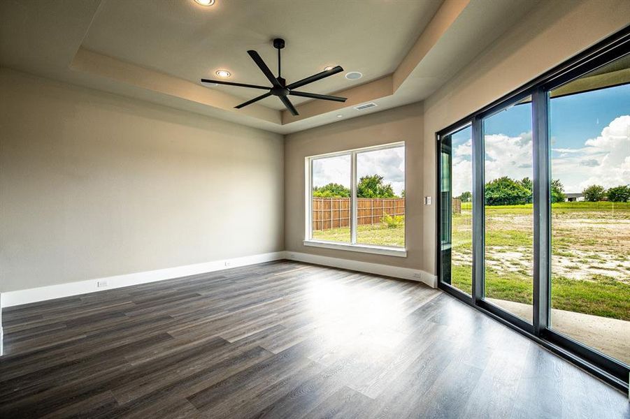 Primary bedroom with sliding glass door out to patio and backyard