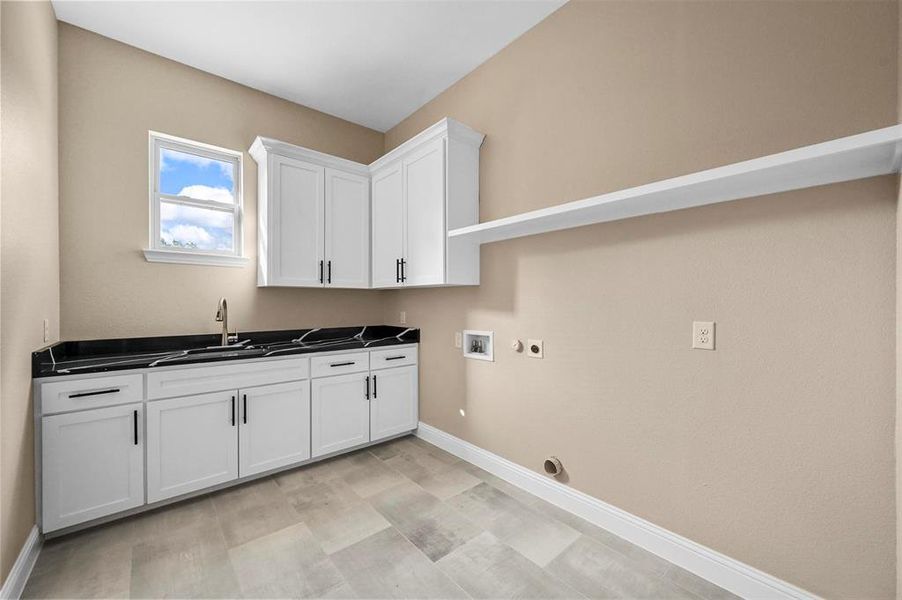 Washroom with hookup for an electric dryer, sink, light hardwood / wood-style floors, cabinets, and hookup for a washing machine