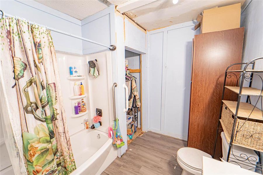 Bathroom featuring light wood-style flooring and shower / bath combo Bathroom featuring light wood-style flooring and shower / bath combo