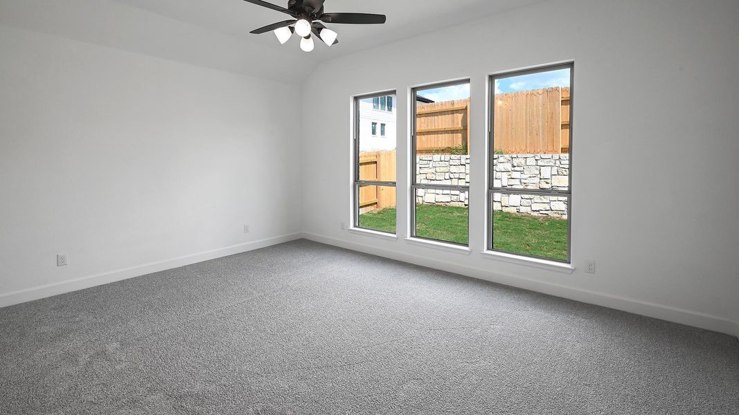 Carpeted spare room with ceiling fan and lofted ceiling Carpeted spare room with ceiling fan and lofted ceiling