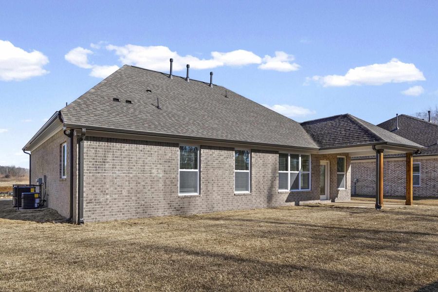 Back of property featuring a patio, brick siding, a shingled roof, and a yard Back of property featuring a patio, brick siding, a shingled roof, and a yard