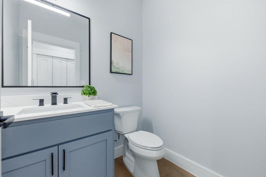 Half bathroom featuring vanity and dark wood-type flooring Half bathroom featuring vanity and dark wood-type flooring