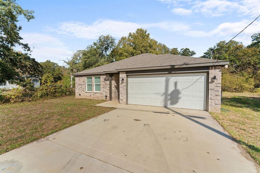 Ranch-style home with a front lawn and a garage