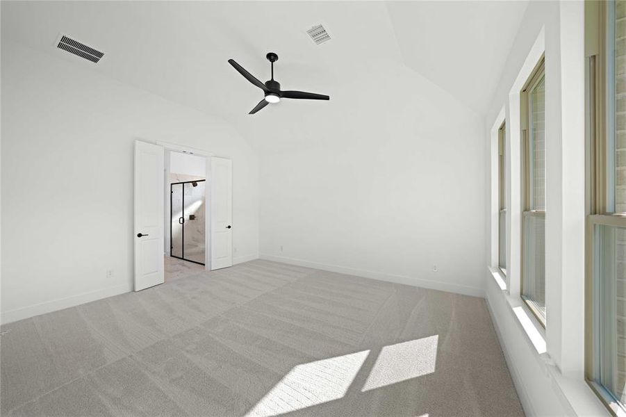 Unfurnished bedroom with lofted ceiling, carpet, and a ceiling fan Unfurnished bedroom with lofted ceiling, carpet, and a ceiling fan