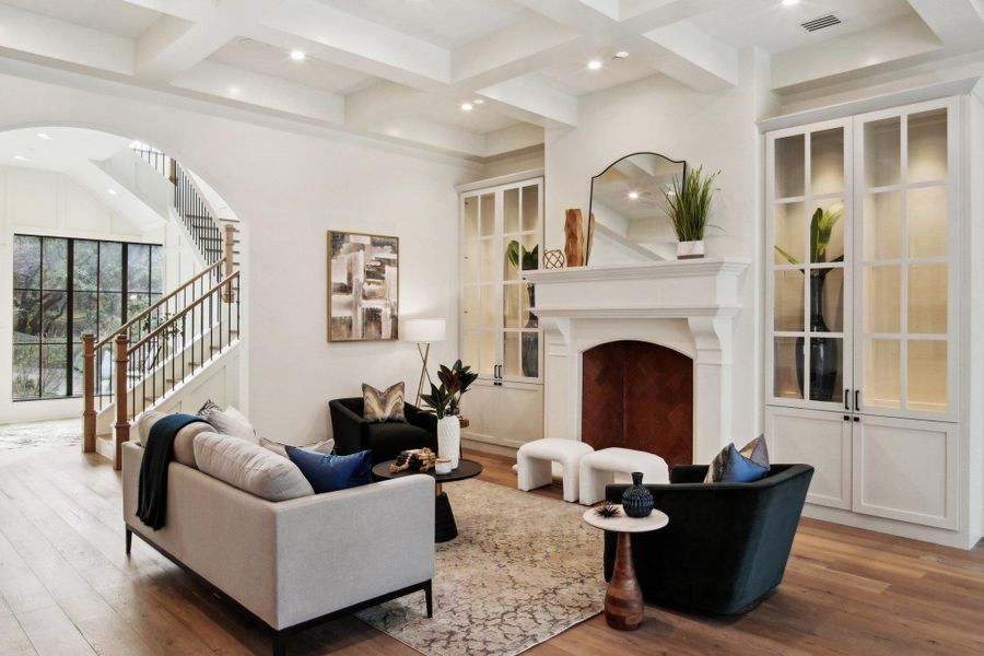 Living area featuring visible vents, beam ceiling, coffered ceiling, and a fireplace