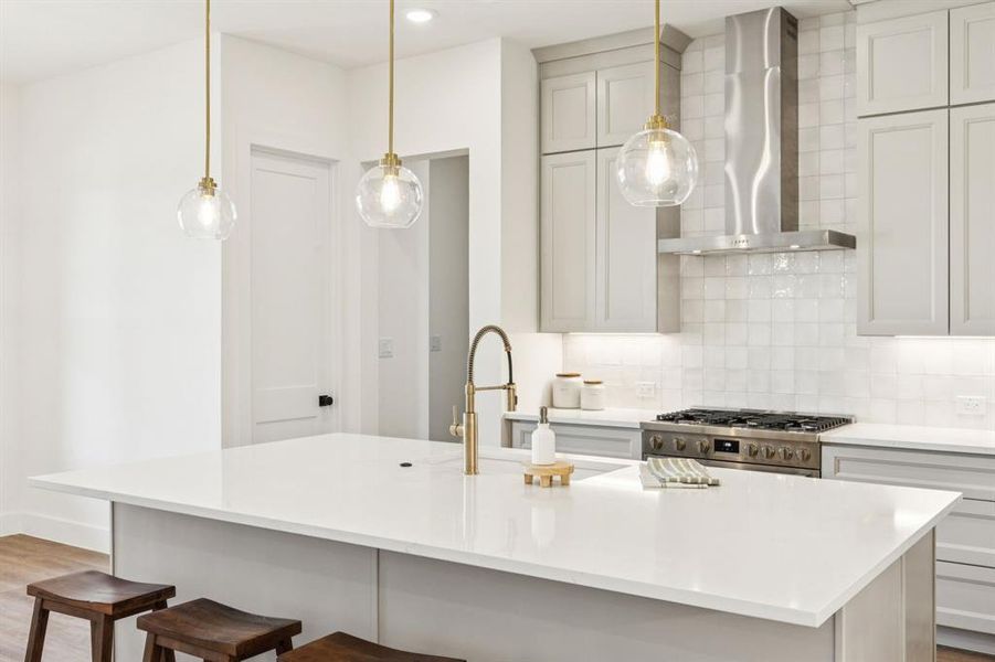 Oversized Island with Pendant Lighting and Gold Faucet