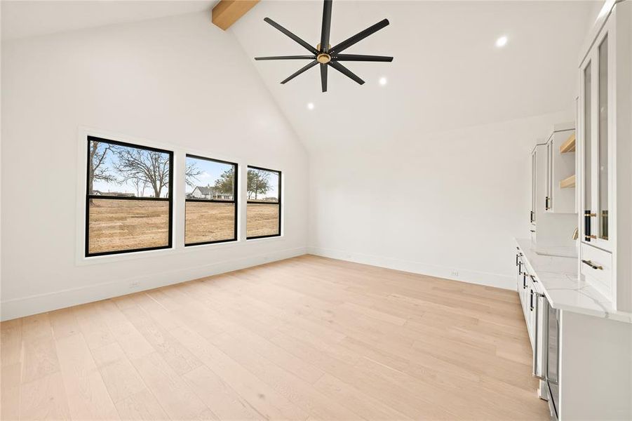 Unfurnished room with high vaulted ceiling, light wood-type flooring, beam ceiling, ceiling fan, and recessed lighting