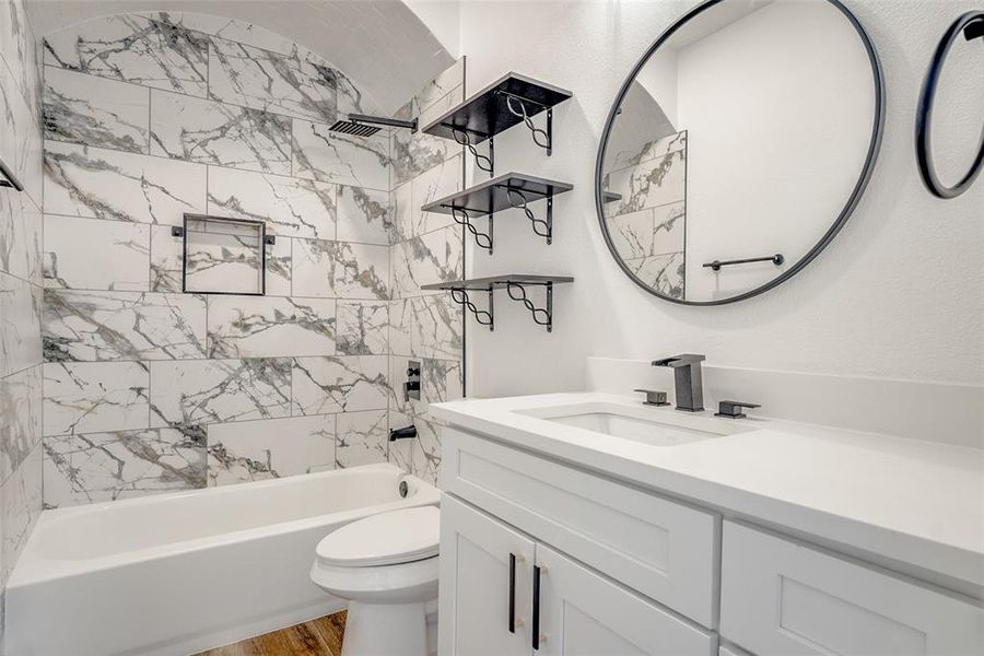 Bathroom featuring shower / bathtub combination, vanity, and light wood-style flooring