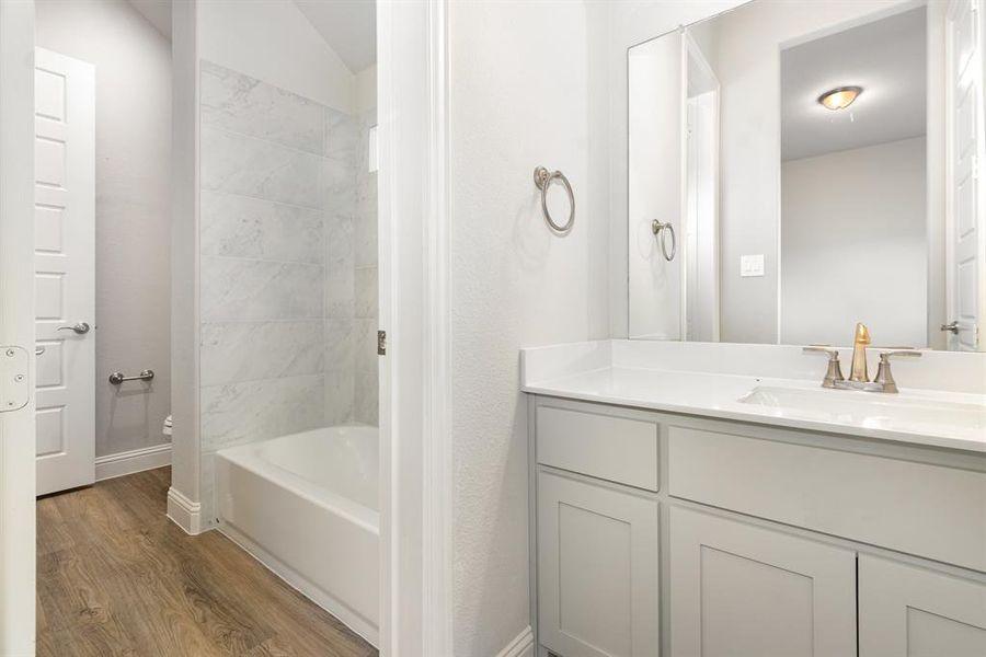 Full bathroom featuring light wood-style flooring, vanity, and shower / washtub combination