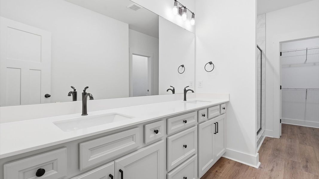 Notable primary bath featuring dual vanity, walk-in shower, and tasteful design touches throughout by DRB Homes Notable primary bath featuring dual vanity, walk-in shower, and tasteful design touches throughout by DRB Homes