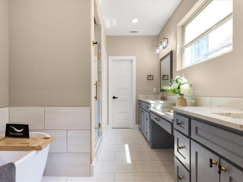 Bathroom with double vanity, a freestanding bath, a stall shower, light tile patterned floors, and recessed lighting