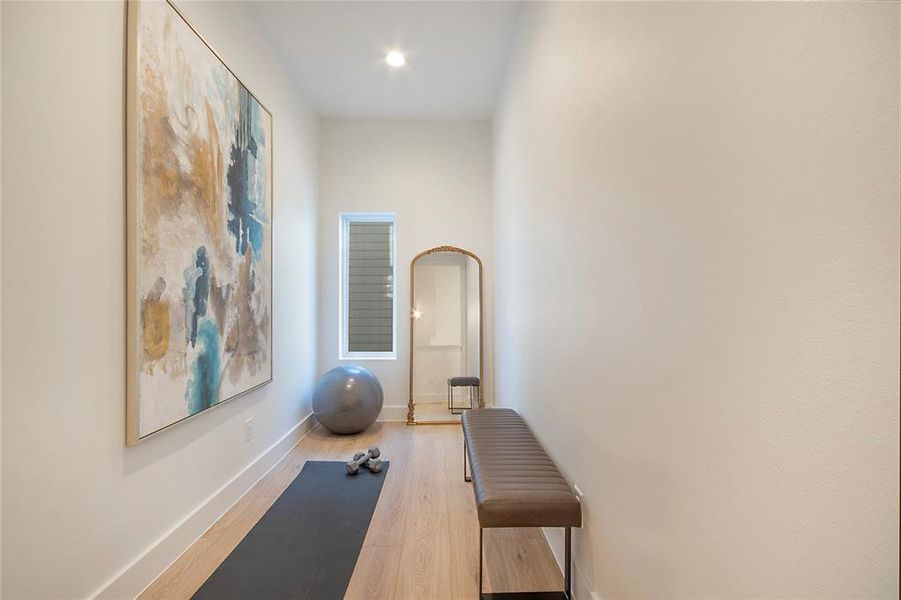 Workout room featuring light wood-type flooring and baseboards Workout room featuring light wood-type flooring and baseboards