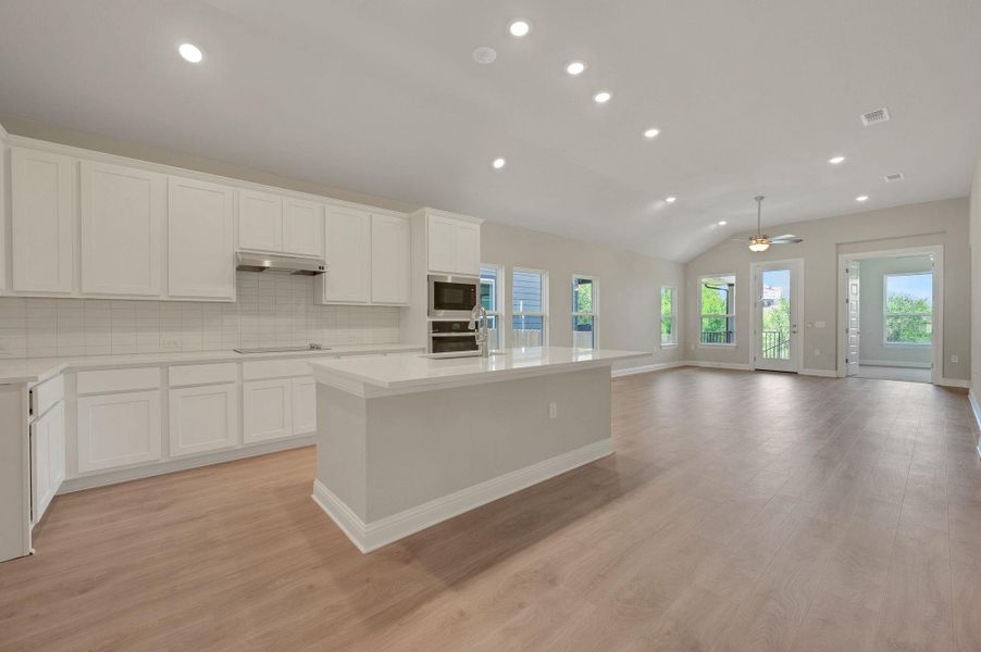 Kitchen with recessed lighting, appliances with stainless steel finishes, range hood, light wood-style floors, and a center island with sink Kitchen with recessed lighting, appliances with stainless steel finishes, range hood, light wood-style floors, and a center island with sink
