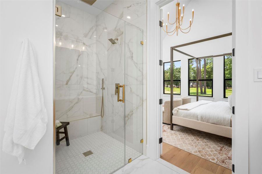 Elegant frameless glass shower, floor-to-ceiling tile, brushed gold fixtures, and a designer niche. Elegant frameless glass shower, floor-to-ceiling tile, brushed gold fixtures, and a designer niche.