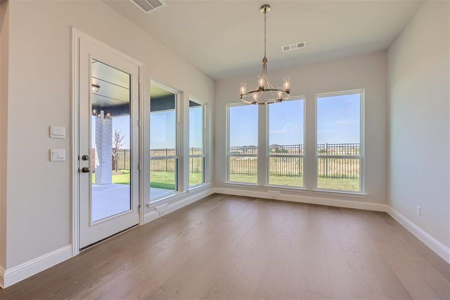 Unfurnished dining area with hardwood / wood-style flooring and an inviting chandelier