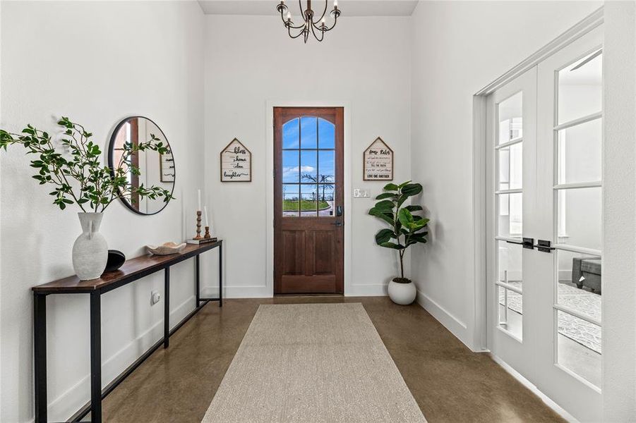 Foyer featuring finished concrete floors and a chandelier Foyer featuring finished concrete floors and a chandelier