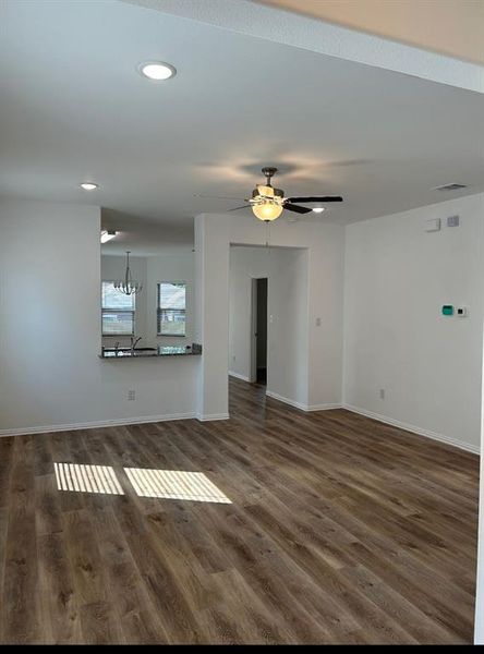 Living room with ceiling fan; laminate wood-type flooring.