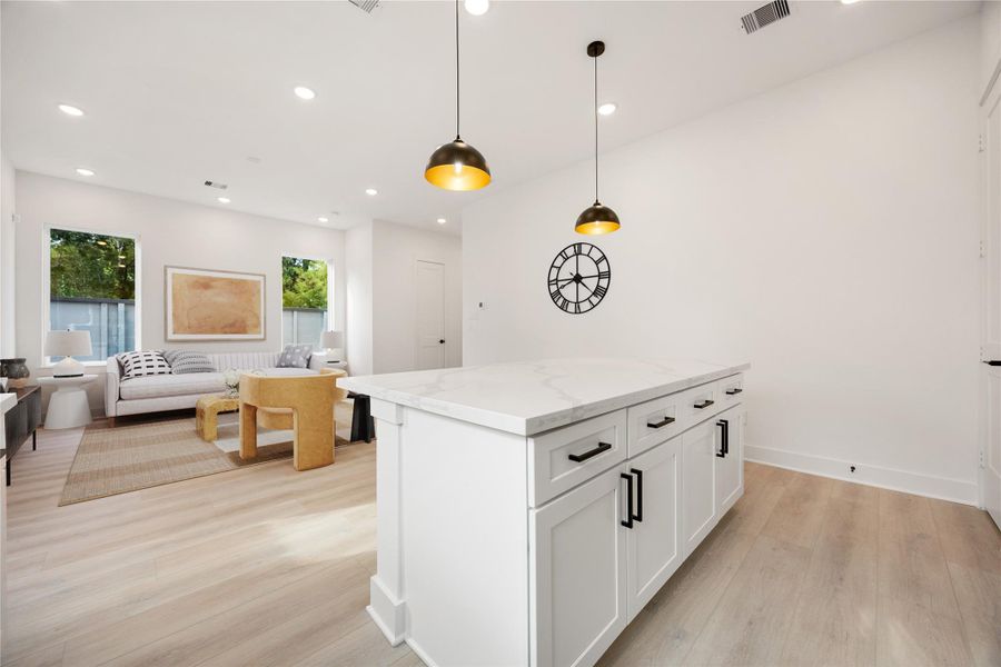 The quartz countertop kitchen island is perfect for conversation or that much needed space to lay out your party spread for everyone to enjoy! The modern pendant lighting adds charm to this space! *Virtually Staged