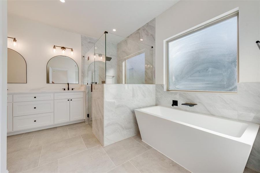 Bathroom with tile walls, vanity, shower with separate bathtub, and tile patterned floors