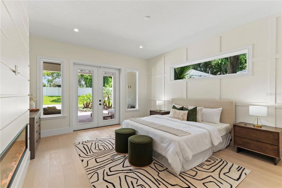 Primary suite with French doors for private access to the backyard, electric fireplace, walk-in closet and beautiful spa-like en suite bathroom. Primary suite with French doors for private access to the backyard, electric fireplace, walk-in closet and beautiful spa-like en suite bathroom.