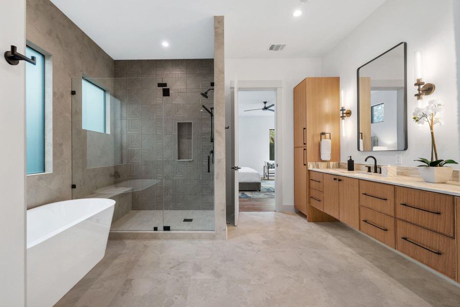 Full bath featuring vanity, a soaking tub, a stall shower, ensuite bathroom