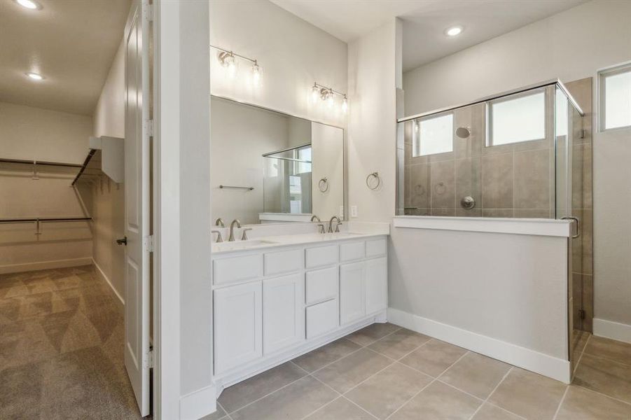 Bathroom with walk in shower, tile patterned flooring, and vanity