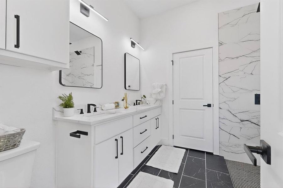Full bathroom with double vanity and dark marble finish flooring