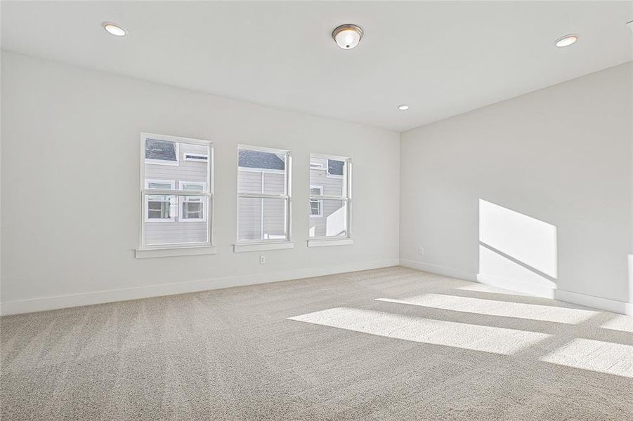 Unfurnished room with light colored carpet and recessed lighting