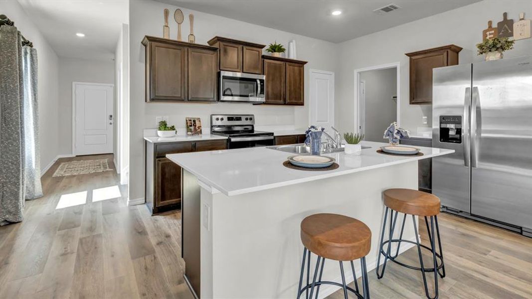 Open-concept kitchen with a central island featuring a white countertop Open-concept kitchen with a central island featuring a white countertop