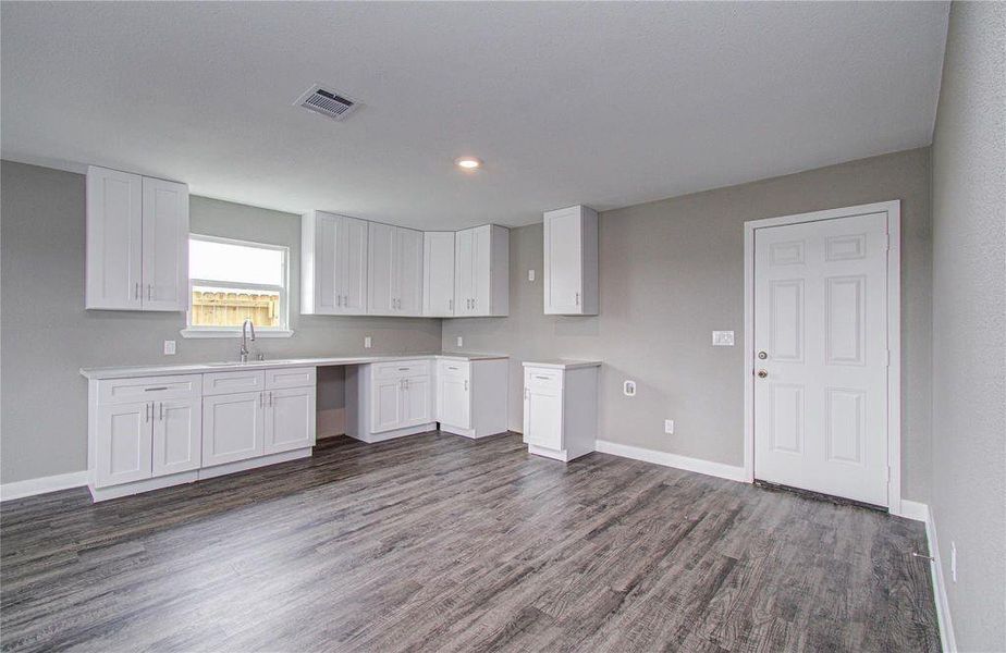 Functional kitchen layout with abundant storage, generous counters, and direct backyard access.