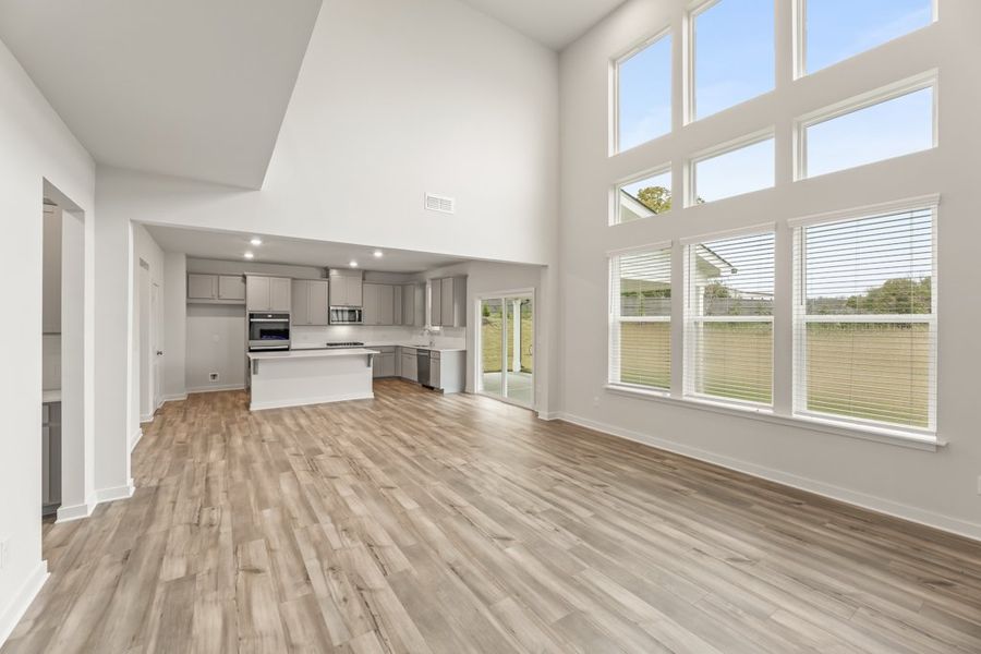 A large empty room with a wood floor and a large window. A large empty room with a wood floor and a large window.