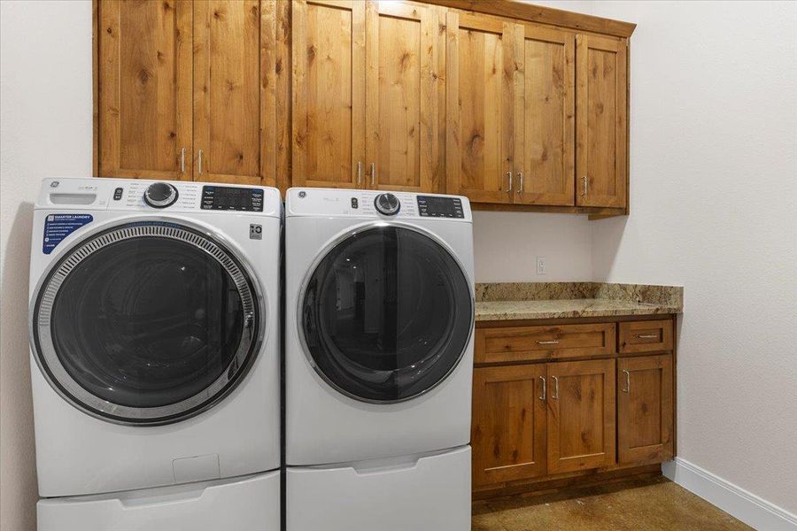 Washroom featuring washing machine and clothes dryer and cabinet space