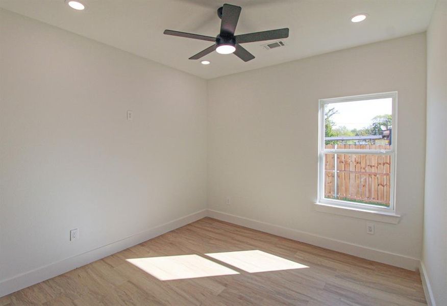 Empty room featuring light wood-style flooring, recessed lighting, and a ceiling fan Empty room featuring light wood-style flooring, recessed lighting, and a ceiling fan