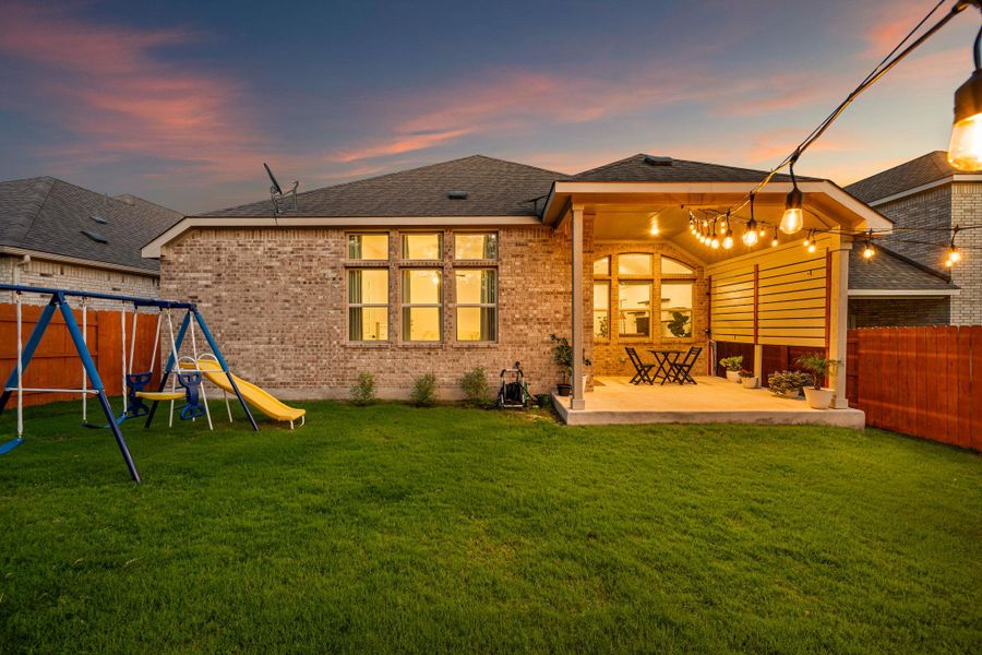 A well-maintained lawn with a playset, extending to a covered patio perfect for evening gatherings. A well-maintained lawn with a playset, extending to a covered patio perfect for evening gatherings.