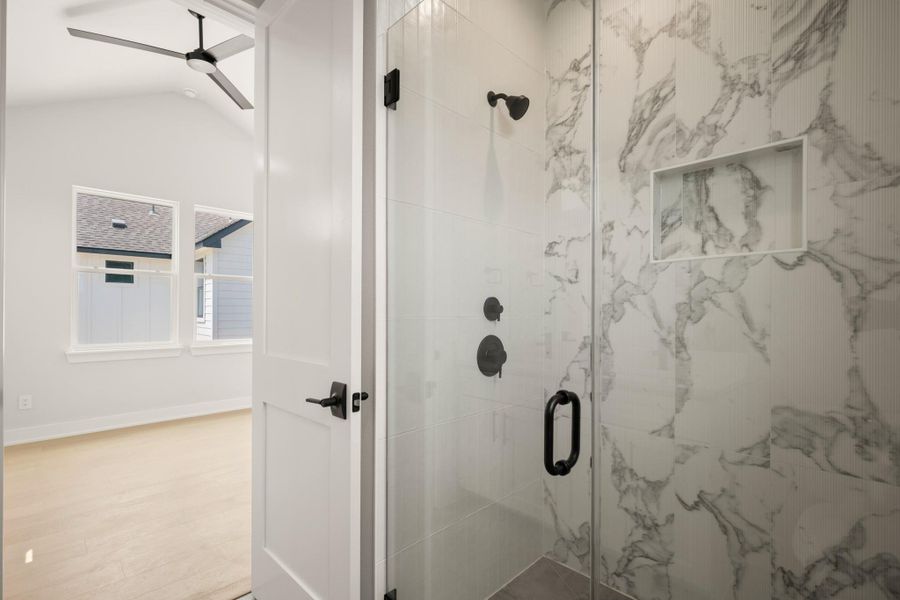 Bathroom with a marble finish shower, a ceiling fan, and wood finished floors Bathroom with a marble finish shower, a ceiling fan, and wood finished floors