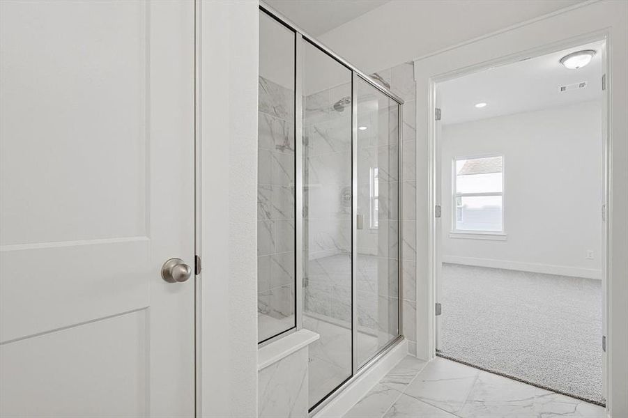 Full bathroom with visible vents, marble finish floor, a marble finish shower, and baseboards