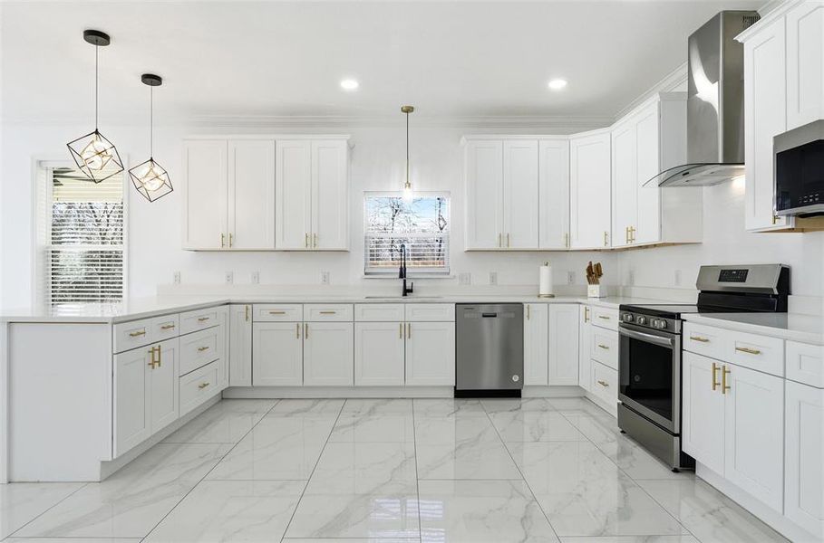 Kitchen with stainless steel appliances, light marble finish flooring, wall chimney range hood, hanging light fixtures, and a peninsula Kitchen with stainless steel appliances, light marble finish flooring, wall chimney range hood, hanging light fixtures, and a peninsula