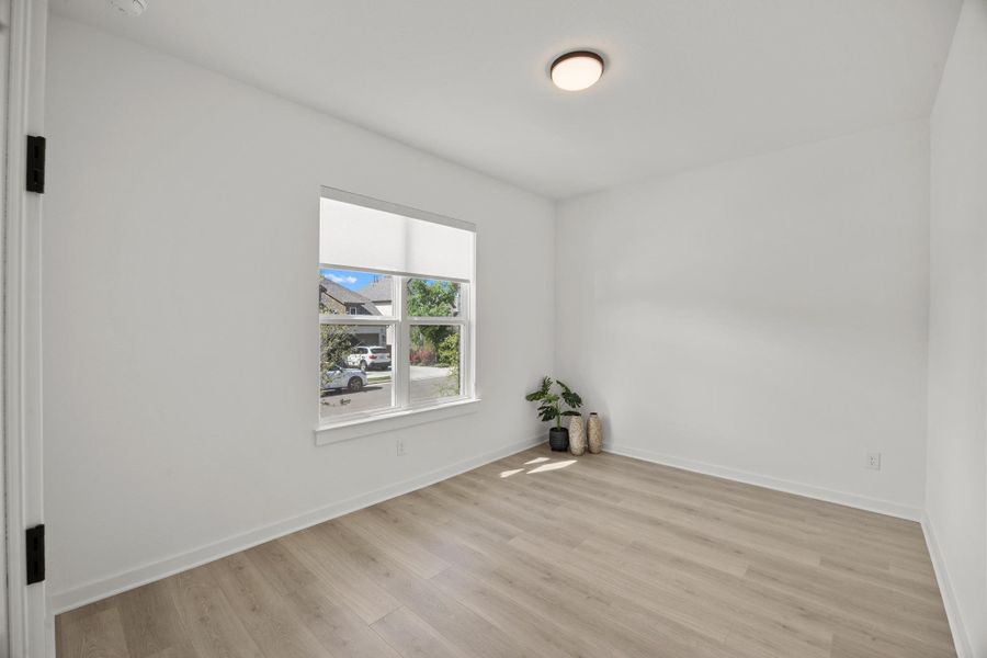 Empty room featuring baseboards and light wood finished floors