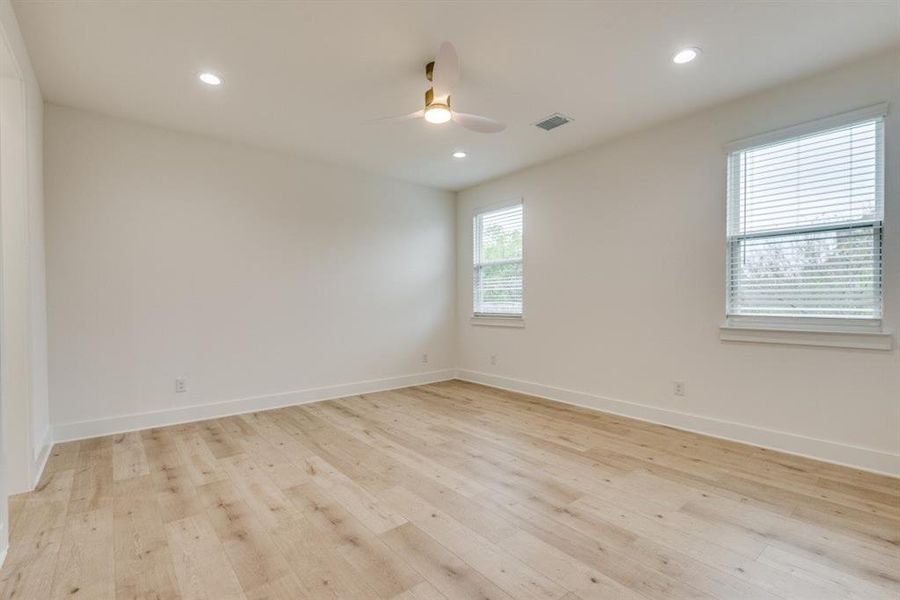 Unfurnished room with ceiling fan, plenty of natural light, and light hardwood / wood-style floors