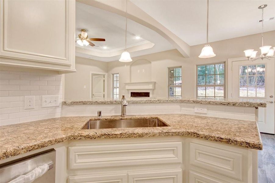 This photo showcases a bright, open-concept kitchen and living area. It features granite countertops, a large sink, stainless steel appliances, and a cozy fireplace. Natural light pours in through multiple windows, and there's a view of the outdoors. The space is inviting and ideal for entertaining. This photo showcases a bright, open-concept kitchen and living area. It features granite countertops, a large sink, stainless steel appliances, and a cozy fireplace. Natural light pours in through multiple windows, and there's a view of the outdoors. The space is inviting and ideal for entertaining.