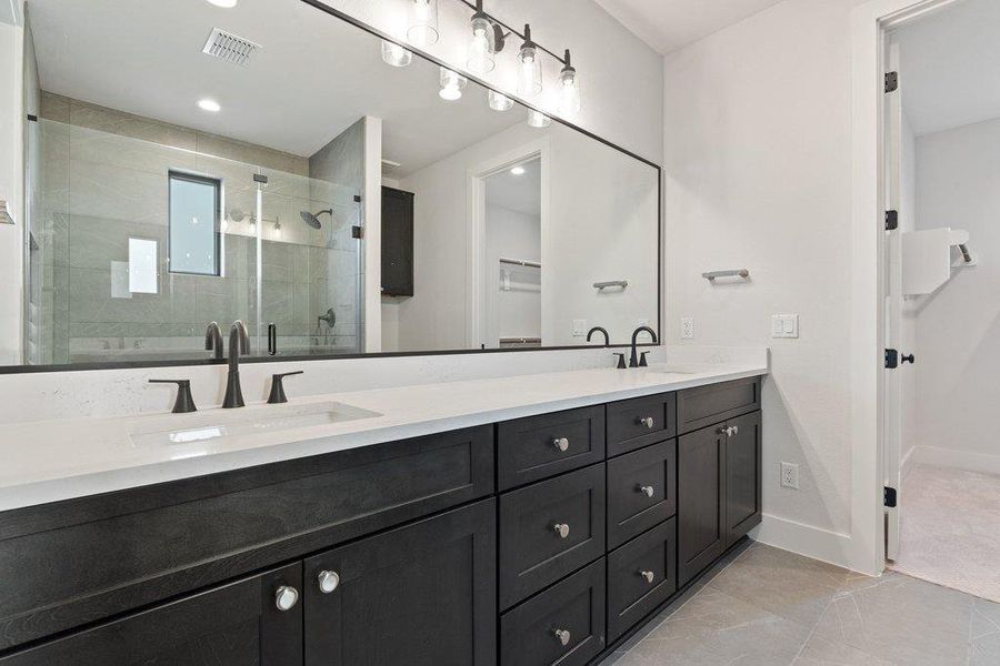 Full bath featuring a stall shower, double vanity, recessed lighting, and light tile patterned flooring
